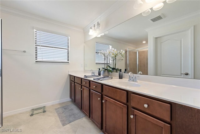 bathroom featuring ornamental molding, a stall shower, a sink, and visible vents