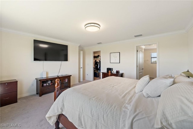 bedroom with ornamental molding, visible vents, a walk in closet, and light colored carpet