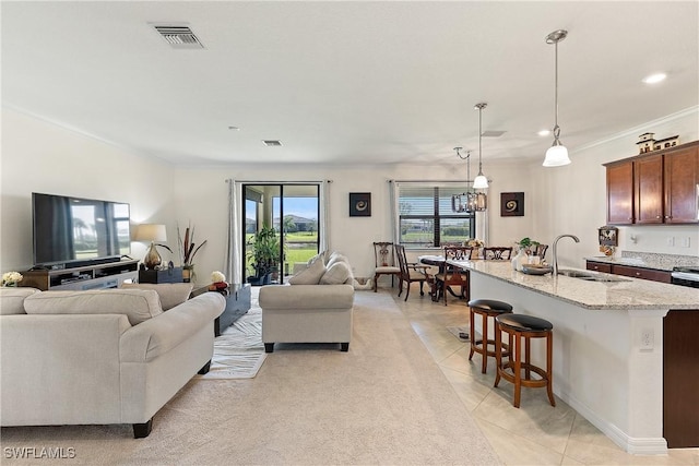 living area featuring visible vents, ornamental molding, and light tile patterned flooring