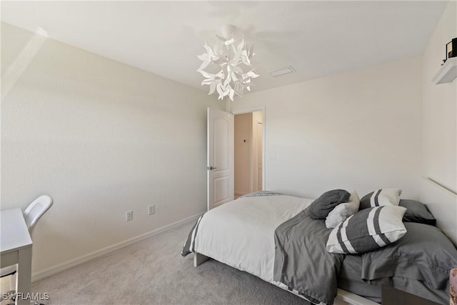 carpeted bedroom featuring a notable chandelier and baseboards