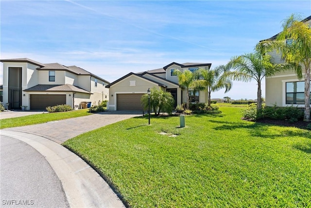 view of front of house featuring a garage, a front lawn, and decorative driveway