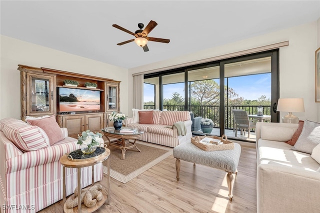 living room with light wood-type flooring and ceiling fan