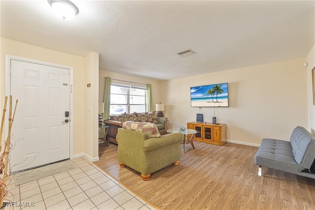 living area featuring baseboards, visible vents, and light wood-style floors