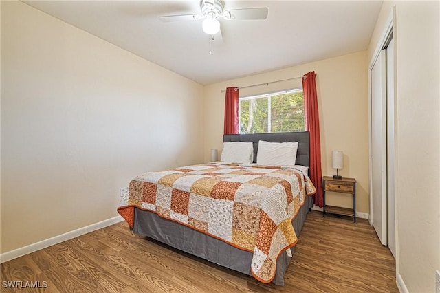 bedroom featuring ceiling fan, a closet, wood finished floors, and baseboards