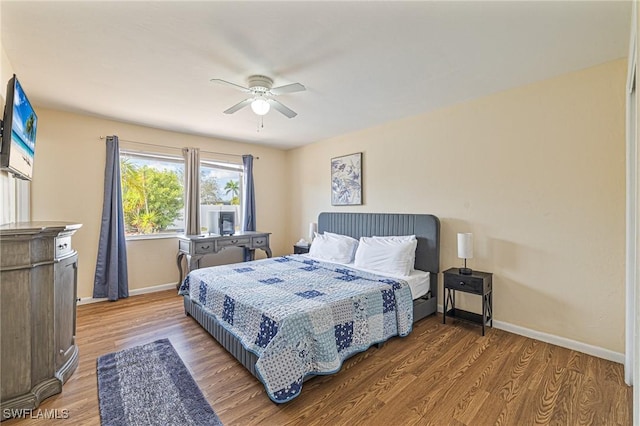 bedroom featuring wood finished floors, a ceiling fan, and baseboards