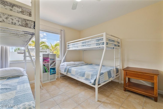 bedroom with light tile patterned floors, a ceiling fan, and baseboards