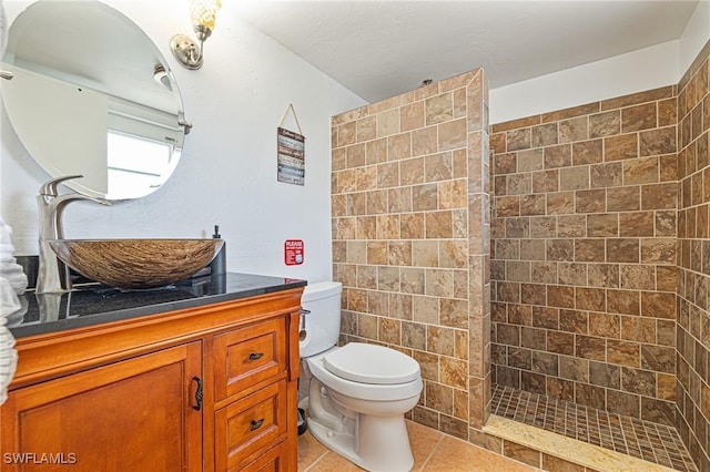 full bath featuring tile patterned flooring, vanity, toilet, and a walk in shower