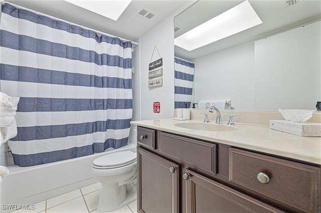 bathroom featuring tile patterned flooring, toilet, a skylight, vanity, and visible vents