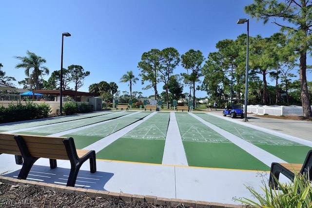 view of home's community featuring fence and shuffleboard