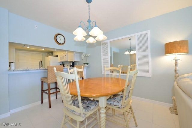 dining area featuring baseboards, a notable chandelier, and light tile patterned flooring