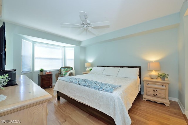 bedroom featuring ceiling fan, light wood finished floors, and baseboards