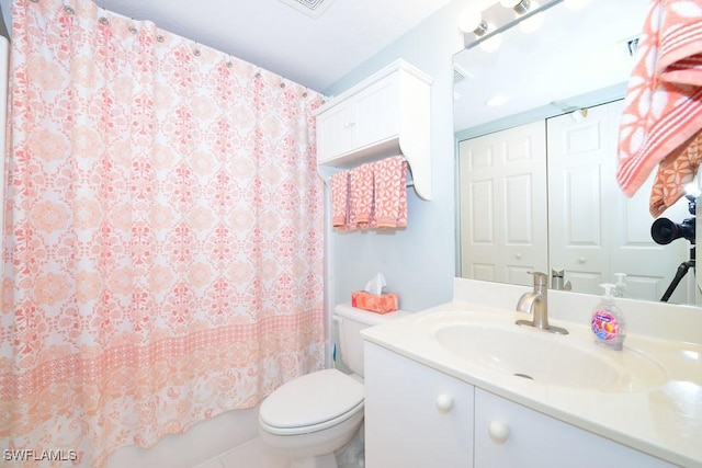 bathroom with tile patterned flooring, vanity, and toilet