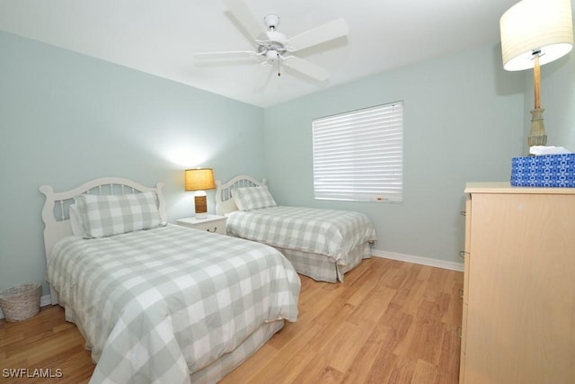 bedroom with a ceiling fan, light wood-type flooring, and baseboards