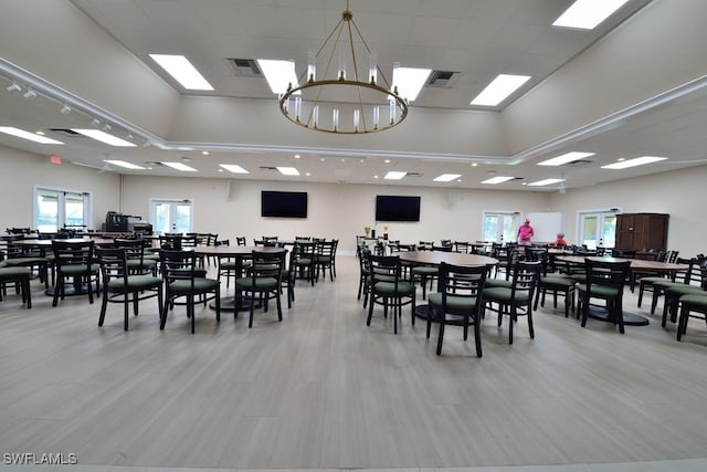 dining area with light wood-style flooring, visible vents, and a chandelier