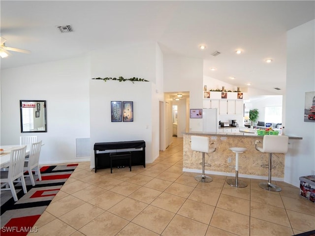 1822 SE 20th St, Cape Coral, FL 33990 - kitchen featuring light tile patterned floors, visible vents, a kitchen breakfast bar, a peninsula, and white cabinets