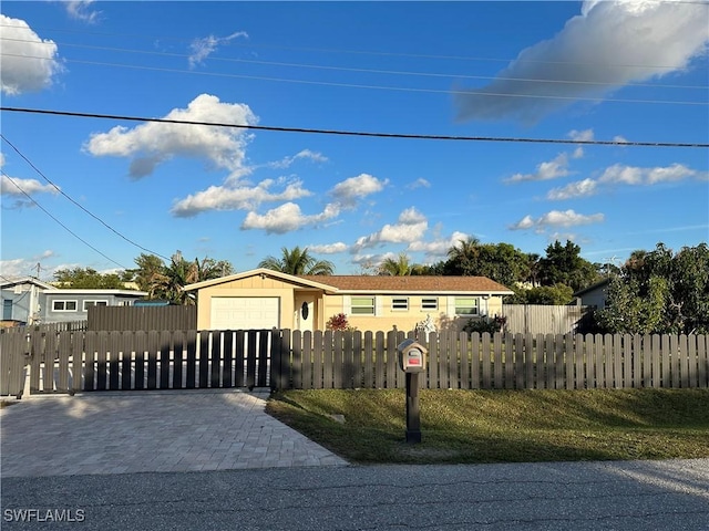 view of front of house with a fenced front yard, decorative driveway, and a garage