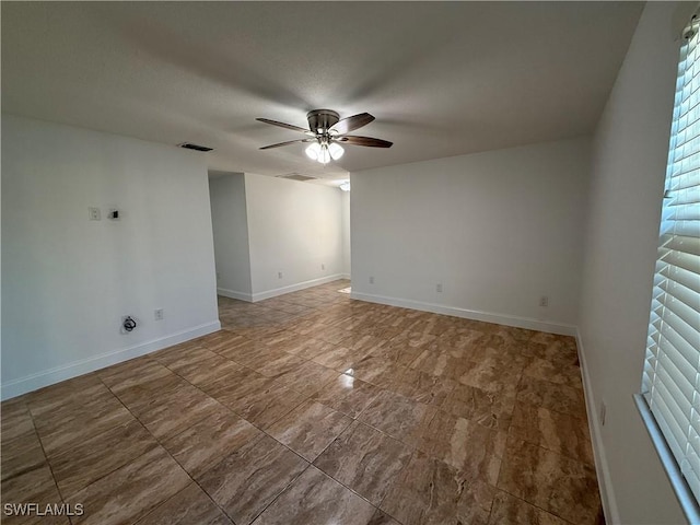 unfurnished room with baseboards, visible vents, and ceiling fan