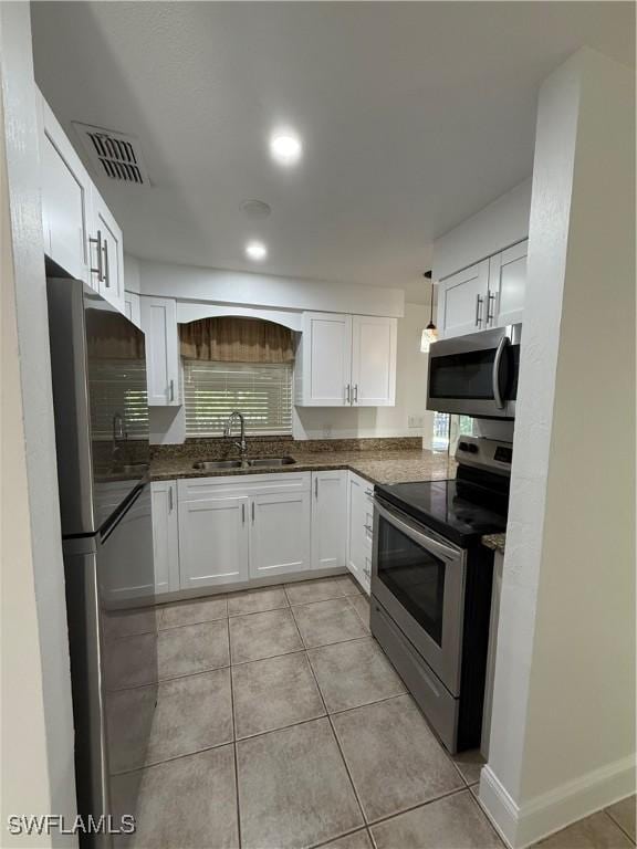 kitchen featuring visible vents, a sink, white cabinetry, appliances with stainless steel finishes, and light tile patterned flooring