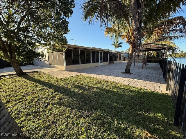 view of yard with a gazebo, fence, a patio, and a sunroom