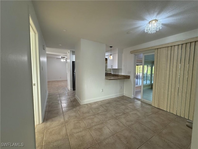 interior space featuring light tile patterned floors, baseboards, and ceiling fan