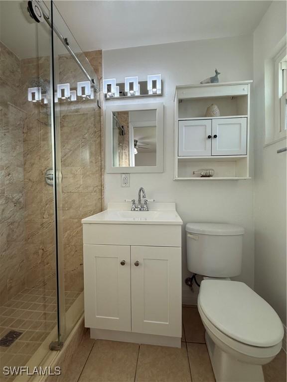 full bath with vanity, toilet, a shower stall, and tile patterned flooring