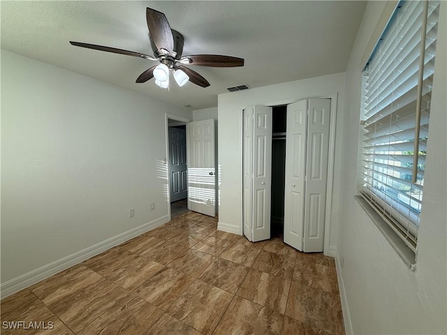 unfurnished bedroom featuring visible vents, a textured ceiling, a closet, baseboards, and ceiling fan