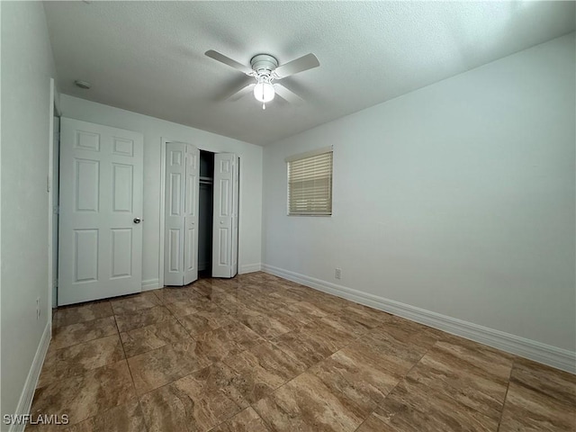 unfurnished bedroom with a closet, baseboards, a textured ceiling, and ceiling fan