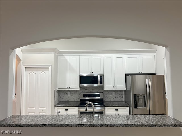 kitchen featuring white cabinets, tasteful backsplash, and appliances with stainless steel finishes