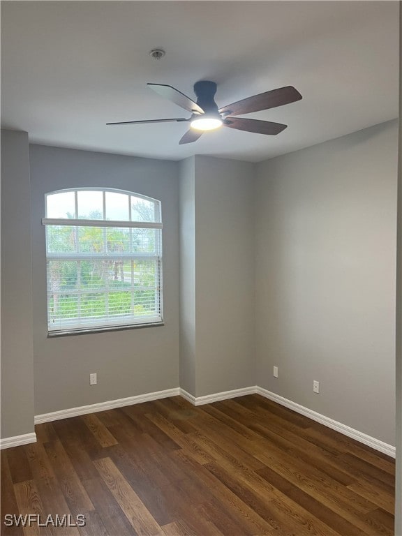 unfurnished room featuring ceiling fan, baseboards, and dark wood-style floors