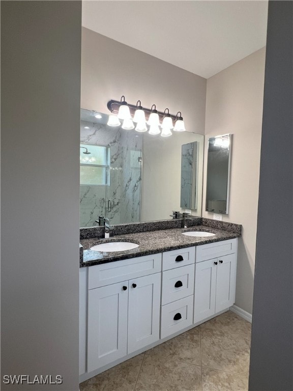 full bathroom with double vanity, tile patterned floors, a marble finish shower, and a sink