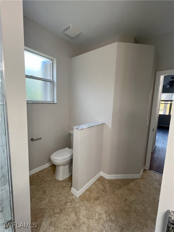 bathroom featuring visible vents, baseboards, toilet, and tile patterned flooring