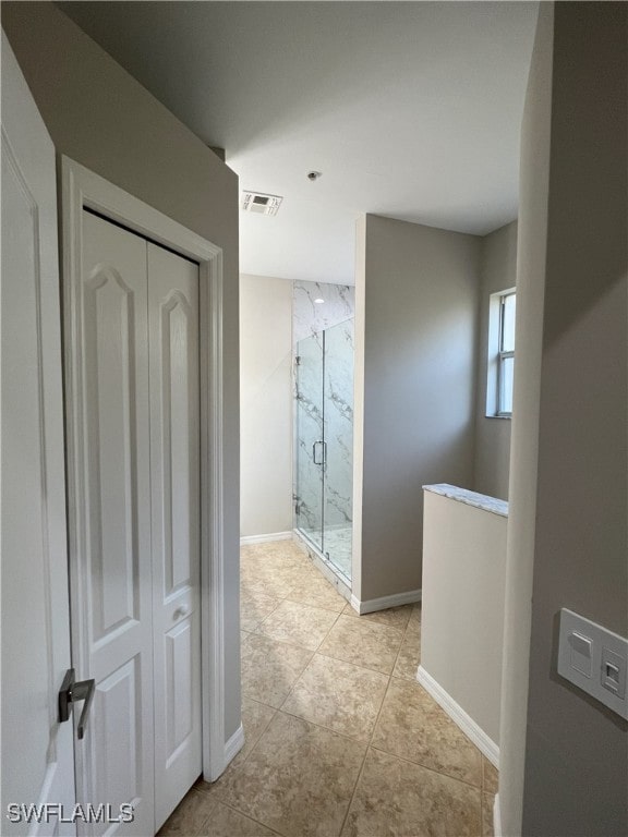 hallway featuring visible vents and baseboards