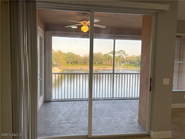 unfurnished sunroom featuring plenty of natural light, a water view, and ceiling fan