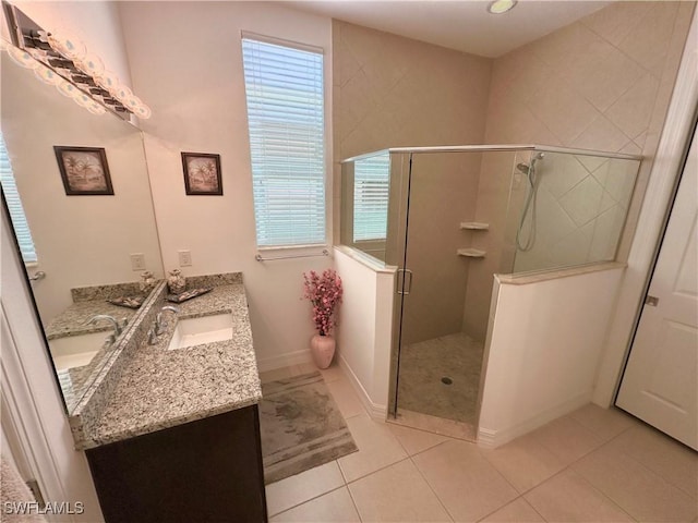 bathroom featuring tile patterned floors, baseboards, a stall shower, and vanity