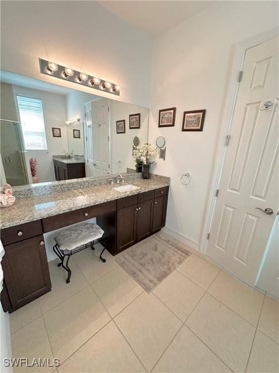 bathroom with tile patterned floors, baseboards, vanity, and a shower stall