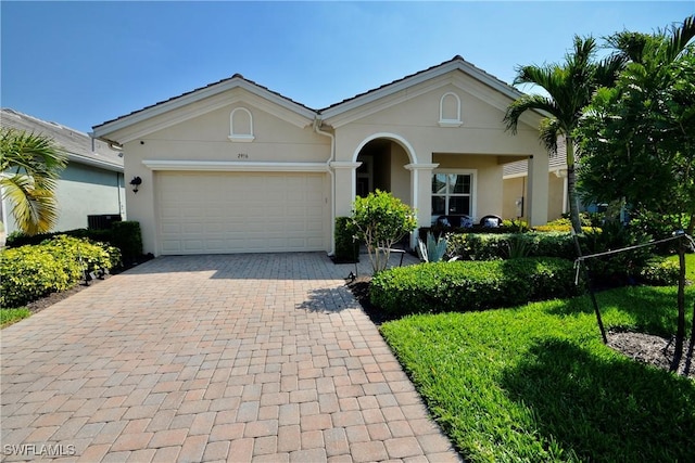 single story home with stucco siding, decorative driveway, and a garage