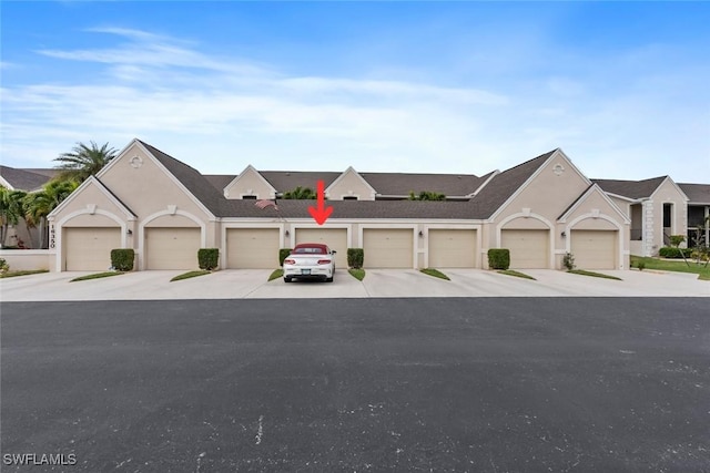 view of front of house with stucco siding and a garage