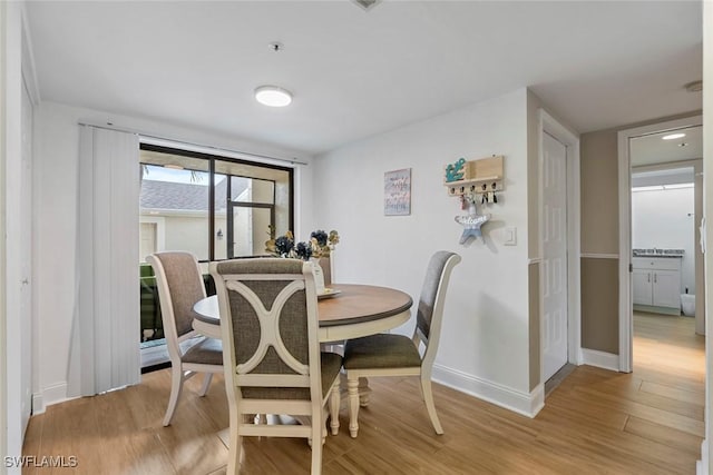 dining room with baseboards and light wood-type flooring