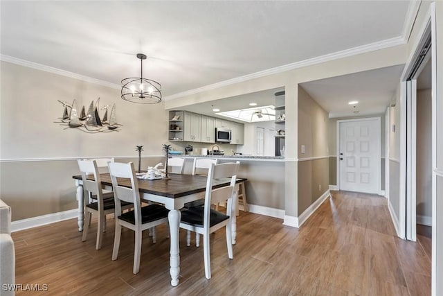 dining area with baseboards, light wood-style flooring, and ornamental molding