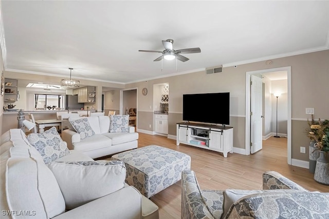 living area with visible vents, light wood-type flooring, and ornamental molding