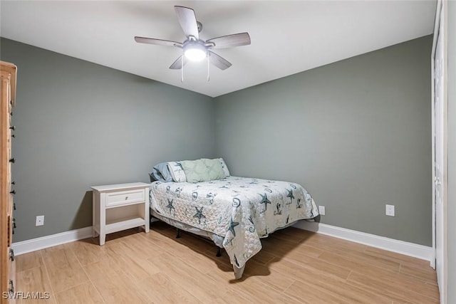 bedroom featuring baseboards, light wood-style floors, and ceiling fan