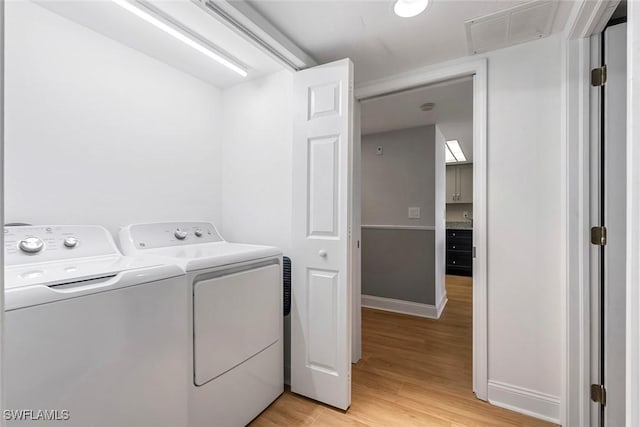 washroom featuring visible vents, independent washer and dryer, light wood-style floors, baseboards, and laundry area