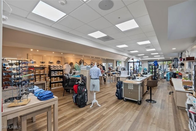 workout area with light wood-style flooring and a drop ceiling