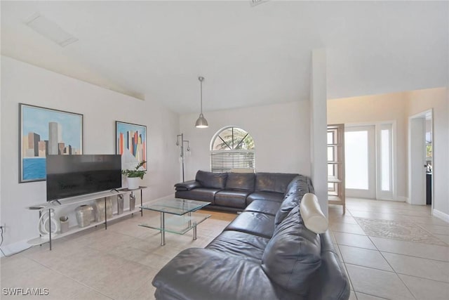 tiled living area with baseboards and lofted ceiling