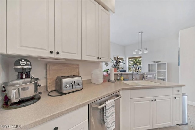 kitchen featuring white cabinetry, a peninsula, a sink, light countertops, and dishwasher