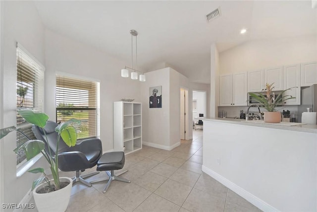 interior space with light tile patterned floors, visible vents, light countertops, white cabinets, and decorative light fixtures