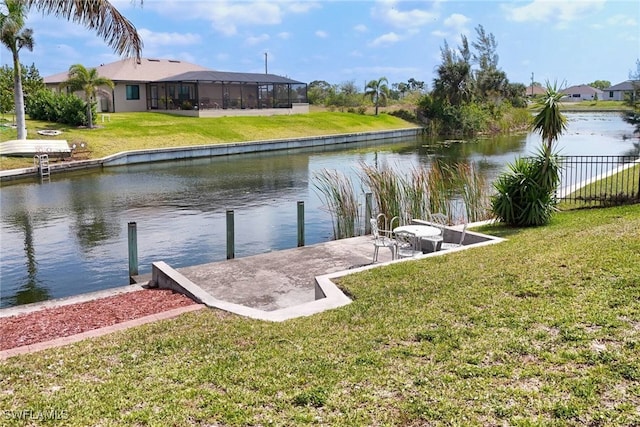 dock area featuring fence, a lawn, and a water view