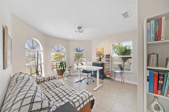 bedroom with multiple windows, light tile patterned floors, baseboards, and visible vents