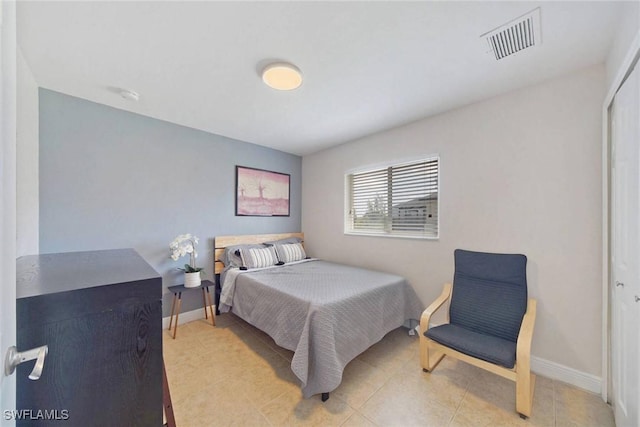 bedroom with tile patterned floors, visible vents, and baseboards