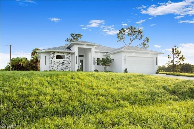 prairie-style house featuring an attached garage, concrete driveway, and stucco siding